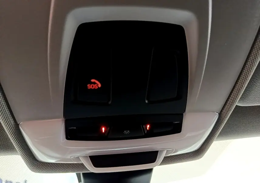 Gros plan sur le plafonnier intérieur avec bouton SOS illuminé en rouge dans une BMW X2 noire 2023.