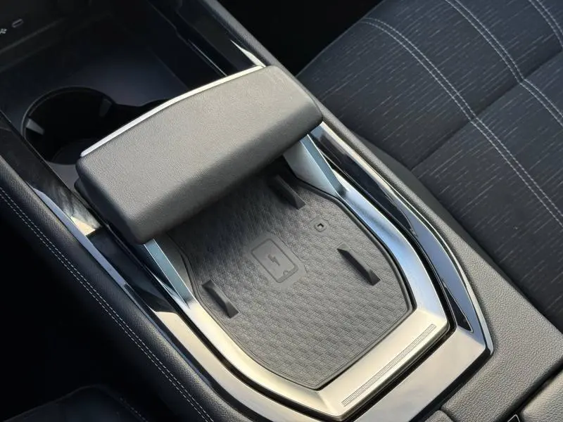 Détail de la console centrale avec repose-bras et zone de charge sans fil du Renault Austral 2025, intérieur noir.