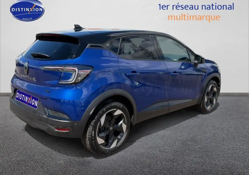 Vue 3/4 arrière droite d'un Renault Captur bleu iron avec toit noir et jantes alu distinctives.