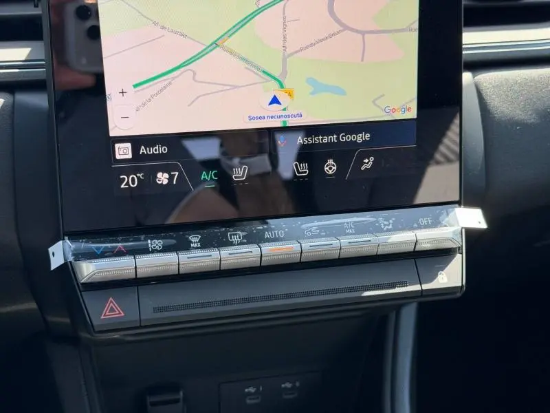 Gros plan sur l'écran tactile et la console centrale du Renault Captur blanc nacré, affichant la navigation et commandes clim.