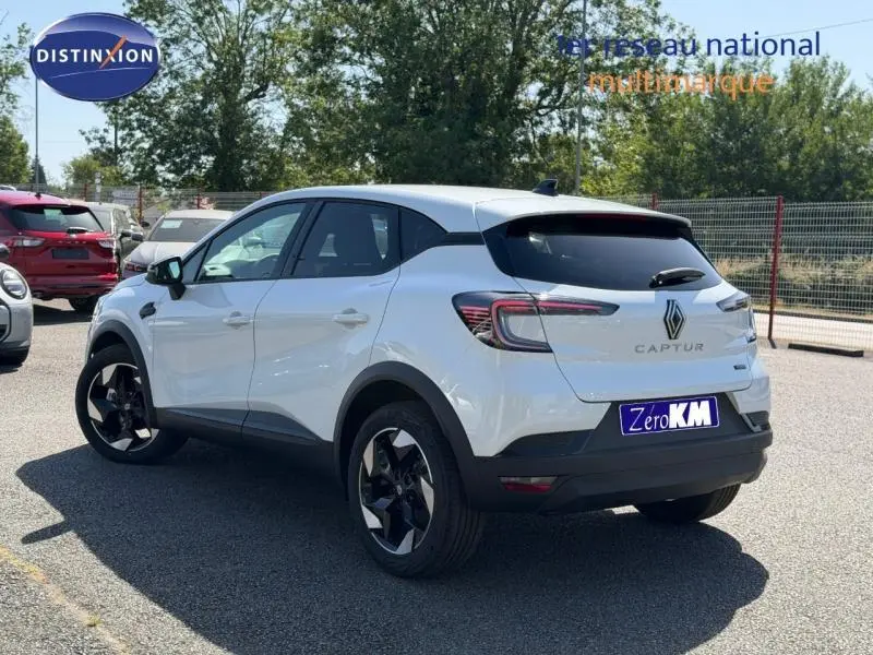 Vue 3/4 arrière droite d’un Renault Captur blanc nacré avec jantes alliage noires et vitres arrière surteintées.