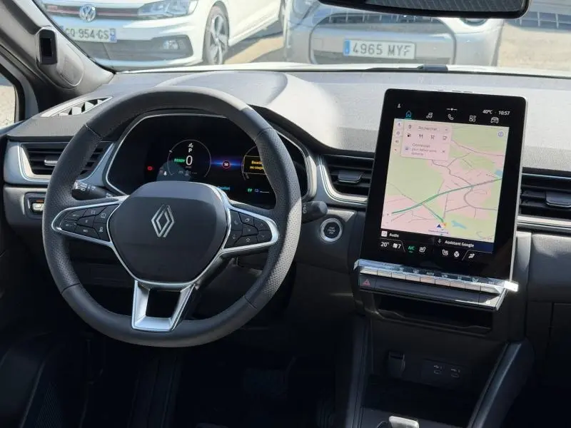 Vue intérieure du tableau de bord du Renault Captur blanc nacré 2026, avec volant multifonction et écran tactile GPS vertical.