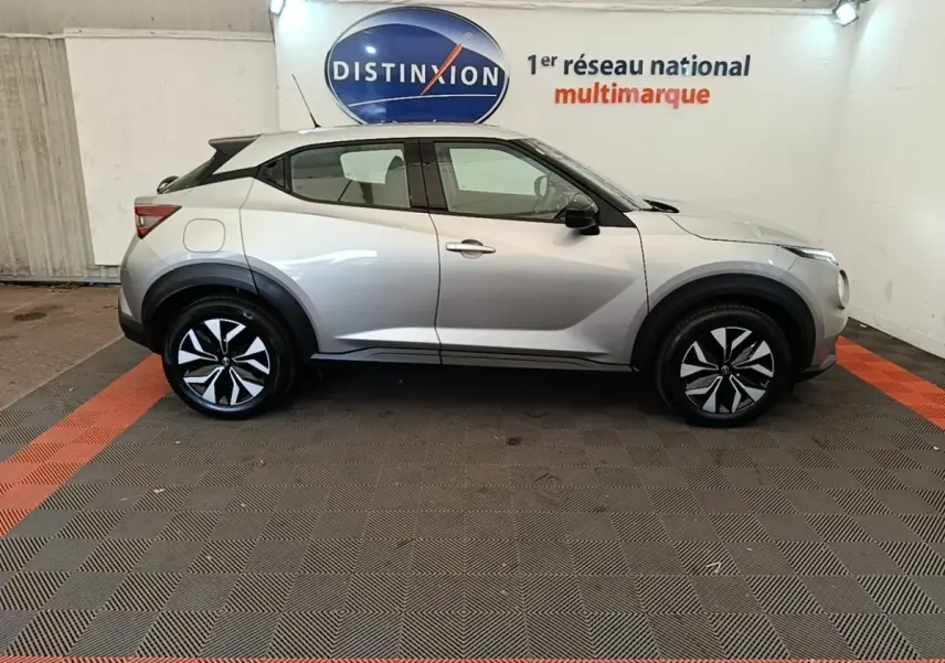 Profil côté gauche du Nissan Juke Business Edition gris clair 2023, avec jantes noires et détails noirs contrastants.
