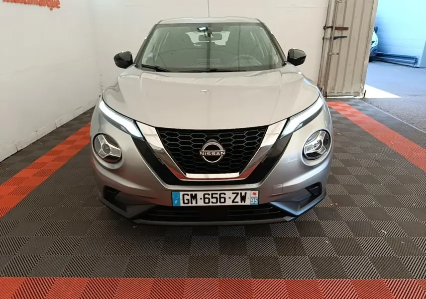 Vue avant frontale d’un Nissan Juke gris clair 2023 avec phares LED et calandre noire chromée.
