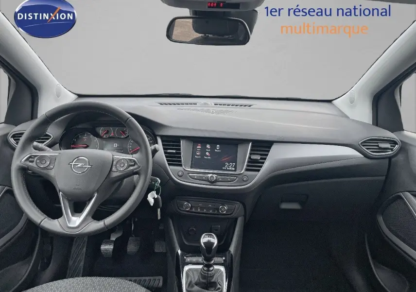 Vue intérieure avant de l'Opel Crossland 2022, tableau de bord noir avec écran tactile et levier de vitesse manuel.