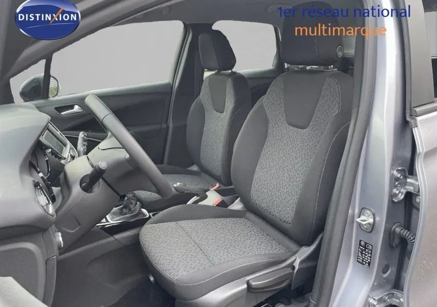 Vue intérieure côté conducteur de l'Opel Crossland gris minéral métal, montrant les sièges en tissu gris et la console centrale.