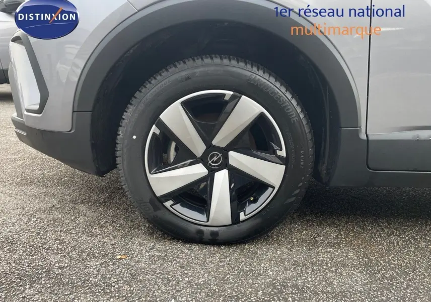 Gros plan sur la roue avant gauche de l'Opel Crossland gris minéral métal avec jante alliage bicolore moderne.