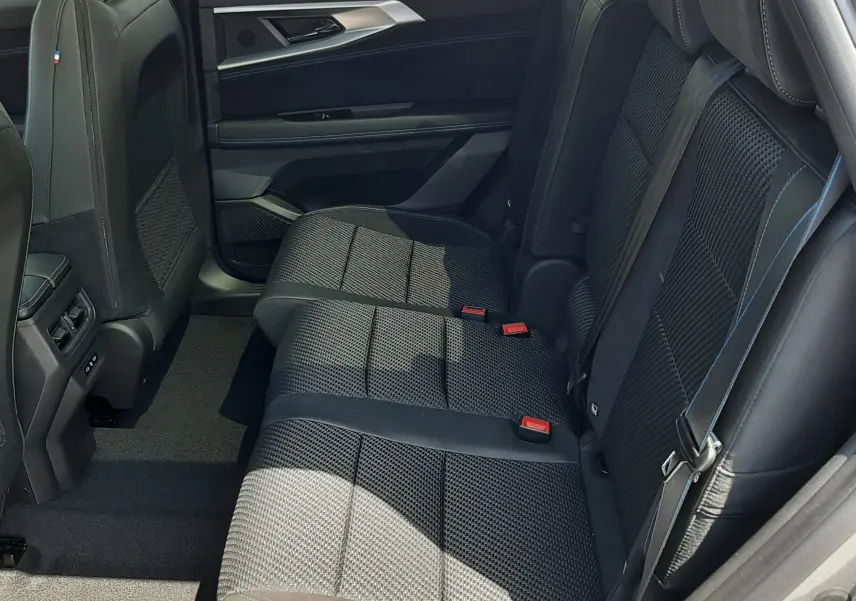 Vue latérale droite de la banquette arrière en tissu noir avec surpiqûres bleues du Renault Espace VI gris schiste métal 2025.