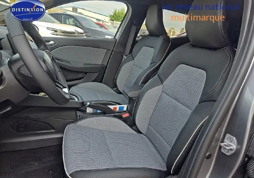 Intérieur de Renault Clio V 1.0 tce 90 techno 2025, vue côté gauche sur sièges tissu gris et accoudoir central.