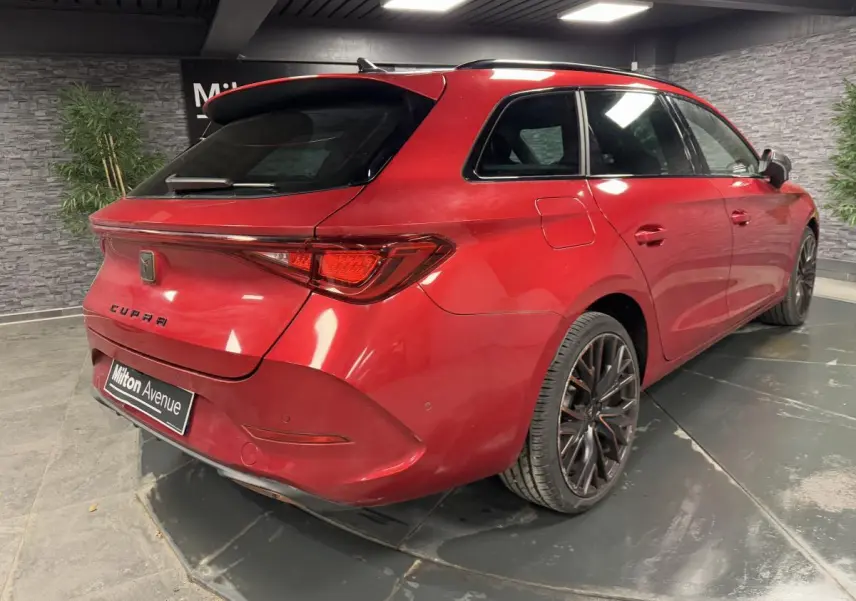 Vue 3/4 arrière droite d'une CUPRA Leon Sportstourer rouge Désir avec jantes alliage 19 pouces et vitres arrière surteintées.