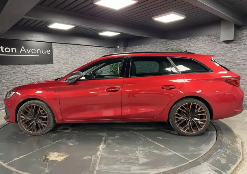 Profil côté gauche d'une CUPRA Leon Sportstourer rouge Désir avec jantes alliage 19 pouces Palm Springs.