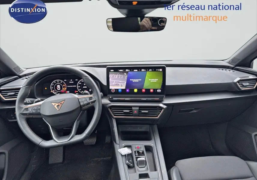 Intérieur de la CUPRA LEON ST 2024 en vue frontale, tableau de bord moderne avec écran tactile et volant cuir noir.