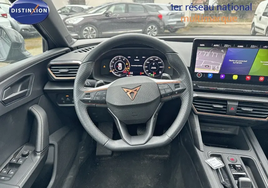 Vue intérieure centrée sur le volant cuir noir et le tableau de bord numérique d'une CUPRA LEON ST 2024.