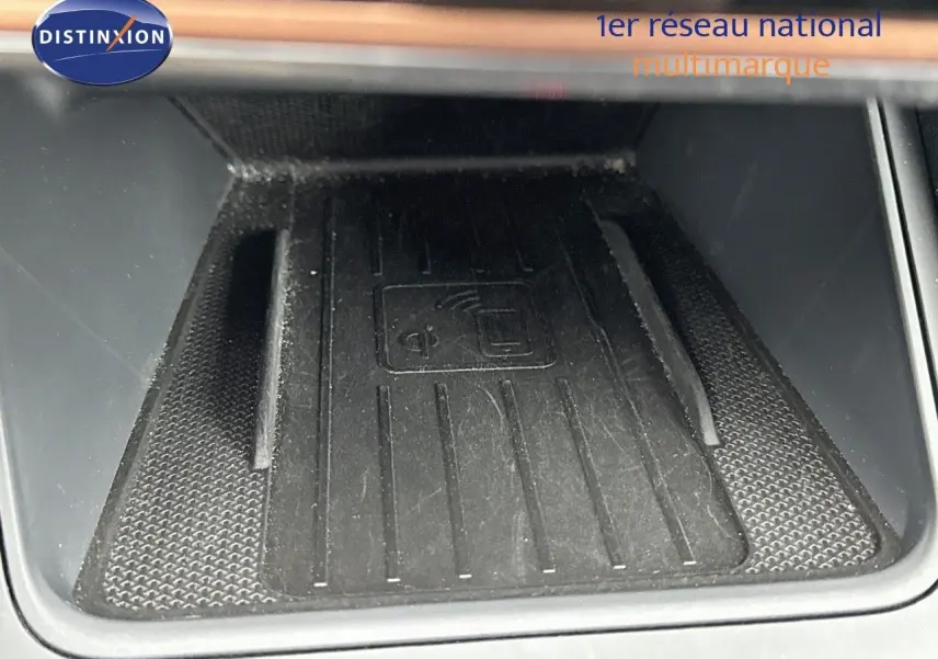Gros plan sur le chargeur sans fil intégré au centre de la console intérieure de la CUPRA LEON ST gris Graphene Metal 2024.