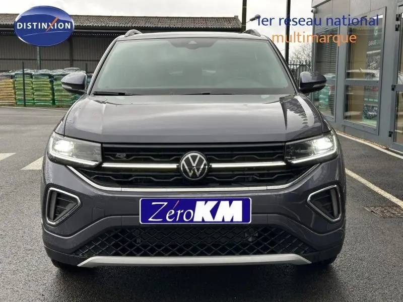 Vue frontale du Volkswagen T-Cross 2025 gris Ascot avec calandre R-Line et feux LED allumés.
