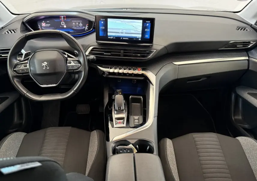 Vue intérieure avant du tableau de bord et volant cuir noir du Peugeot 3008 bleu, avec écran tactile central et commandes modernes.