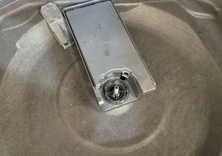 Gros plan sur le coffre gris foncé du Peugeot 3008, montrant le support de roue de secours et un outil plastique.