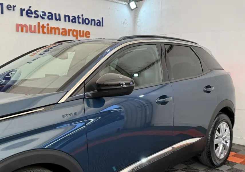 Vue côté gauche du Peugeot 3008 bleu Style 2021 avec rétroviseurs noirs et baguettes chromées sur les portes.