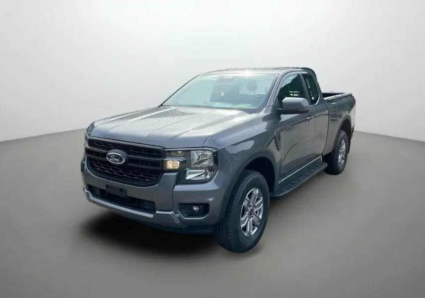 Ford Ranger gris carbone en 3/4 avant droit avec marchepieds latéraux et calandre noire distinctive.