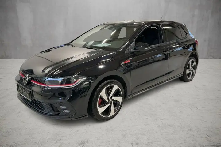 Volkswagen Polo 2.0 TSI GTI noire vue 3/4 avant droit avec jantes alliage 17 pouces et détails rouges sportifs.
