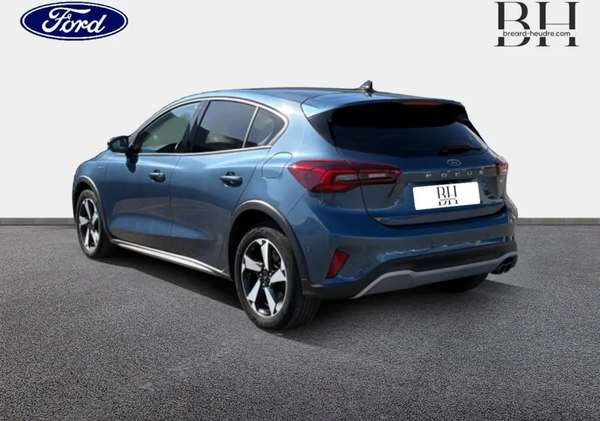 Vue 3/4 arrière droite d'une Ford Focus 2022 bleu azur métallisé avec toit panoramique et vitres arrière surteintées.