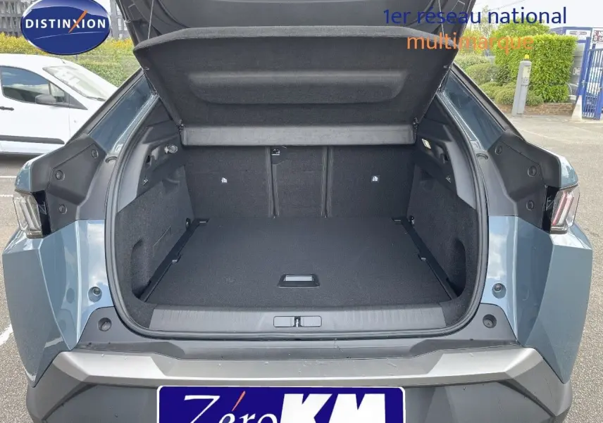 Coffre ouvert en vue arrière d'un Peugeot 3008 Hybrid 2025 bleu Ingaro Metal, montrant un espace de chargement spacieux.