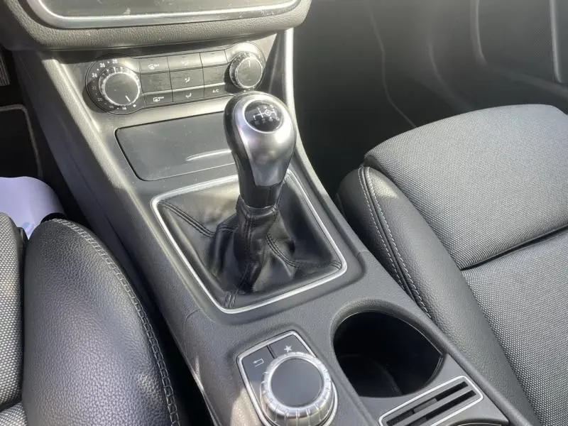 Le levier de vitesse manuel noir du Mercedes GLA 200 D Sensation 2017, avec console centrale et sièges en tissu.