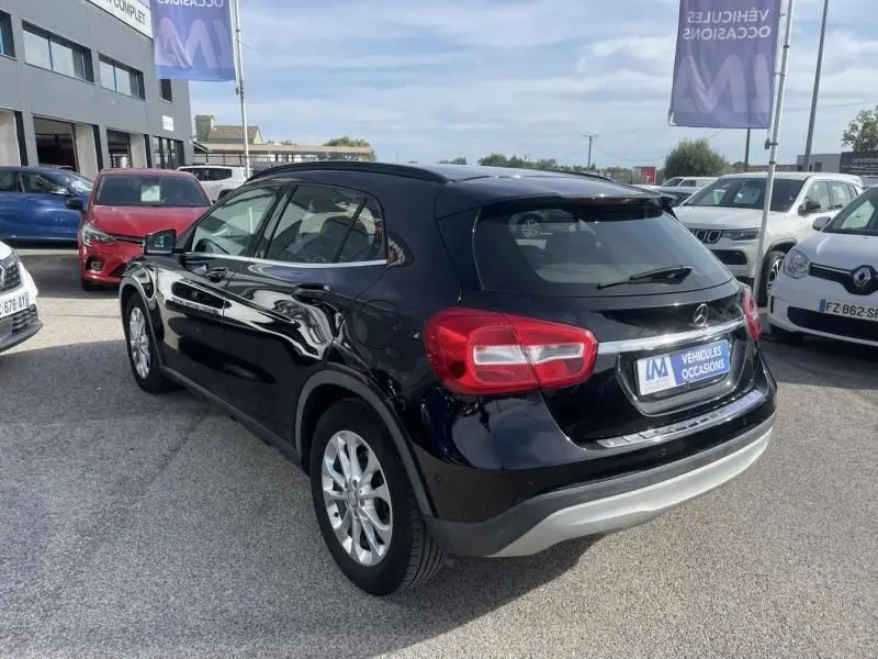 Mercedes GLA 200 D Sensation noir vue 3/4 arrière côté gauche sur parking de véhicules d'occasion.
