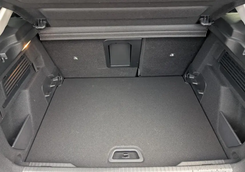 Coffre spacieux et propre de la Citroën C4 2025, vue intérieure arrière avec banquette rabattue et éclairage latéral.