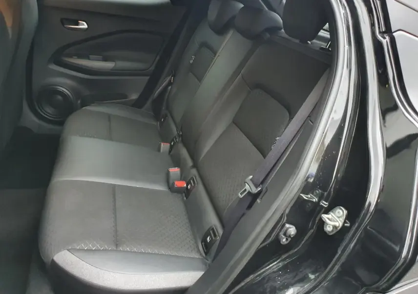 Vue intérieure côté gauche sur la banquette arrière noire du Nissan Juke 2025 avec appuis-tête réglables et ceinture de sécurité.