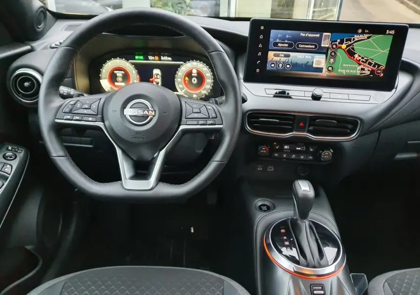 Vue intérieure frontale du tableau de bord du Nissan Juke 2025 avec volant multifonction et écran tactile 12,3 pouces.