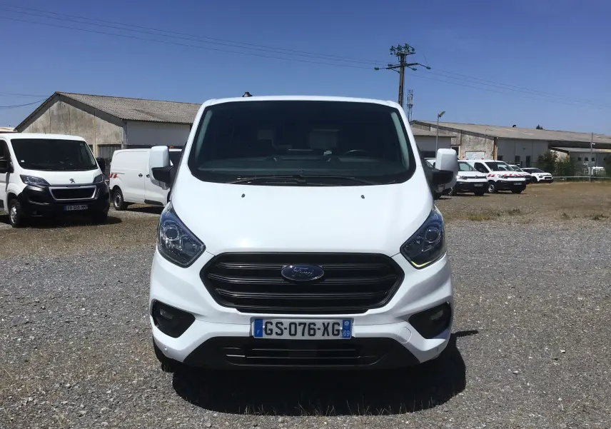 Vue de face d’un Ford Transit Custom Kombi blanc 2023, avec calandre noire et plaque d’immatriculation française visible.