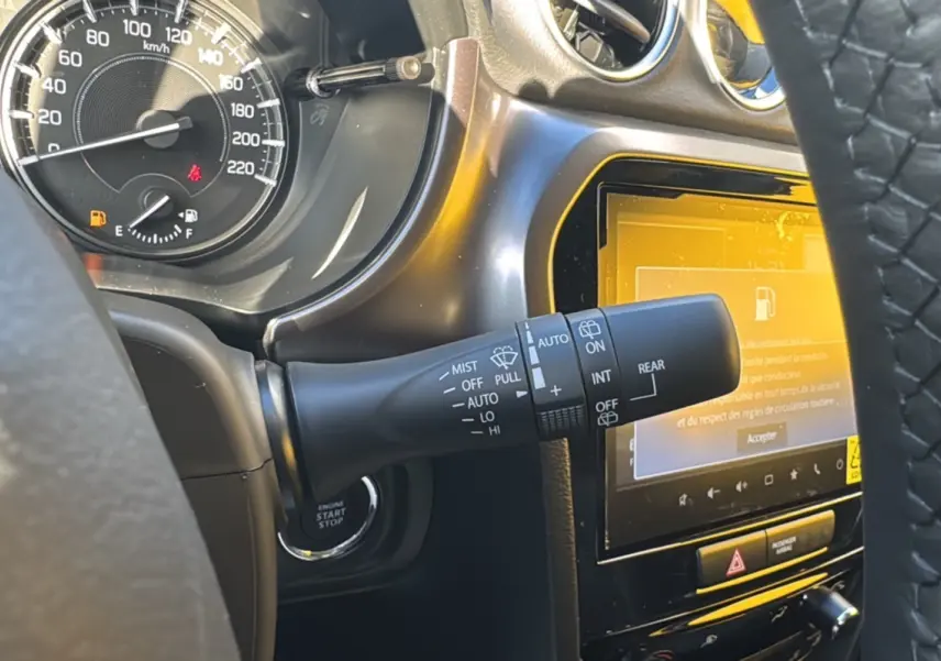Gros plan intérieur sur le commodo d’essuie-glace et l’écran tactile du Suzuki Vitara 2025, finition Privilege Allgrip.