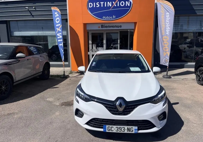 Renault Clio 1.6 E-Tech blanc Quartz vue de face, stationnée devant une concession Distinxion.