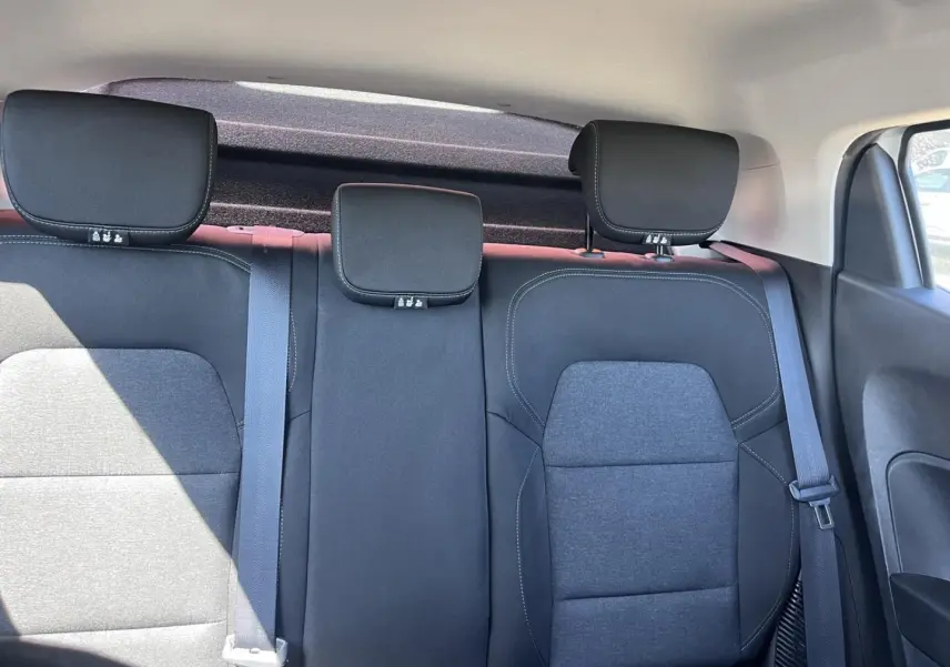 Vue intérieure arrière de la Renault Clio 1.6 E-Tech 2021, sièges tissu noir avec appuie-têtes et ceintures visibles.