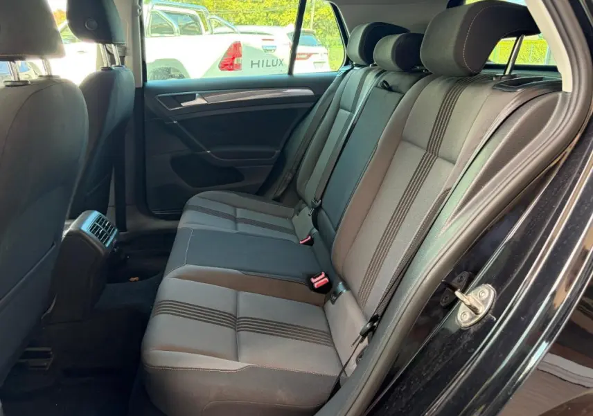 Vue intérieure côté droit des sièges arrière en tissu gris et noir de la Volkswagen Golf 7 noire de 2016.
