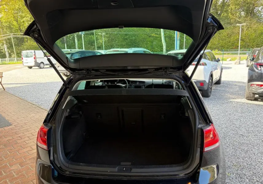 Vue arrière ouverte d'une Volkswagen Golf 7 noire de 2016, mettant en valeur le coffre vide et l'intérieur visible.