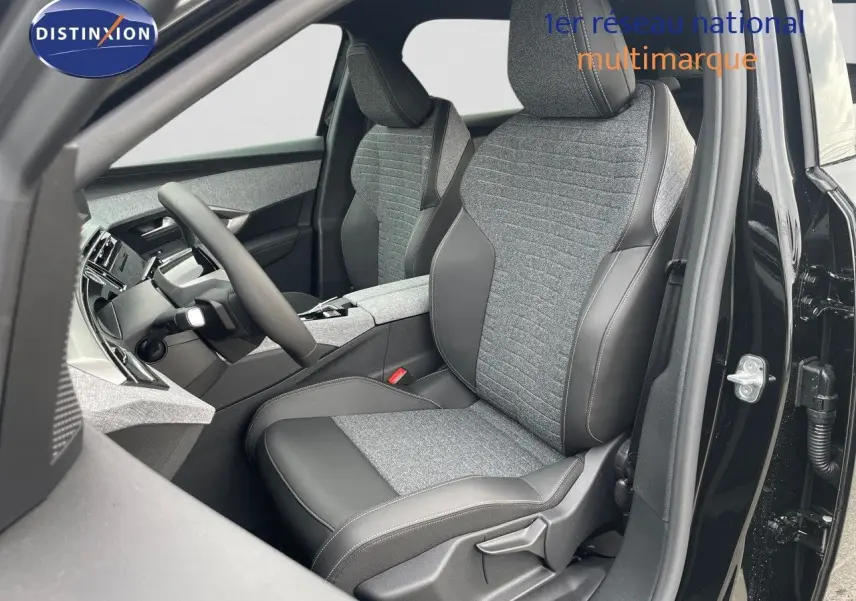 Intérieur du Peugeot 3008 Hybrid 2025 en noir perle métal, vue côté conducteur sur sièges tissu et cuir gris.