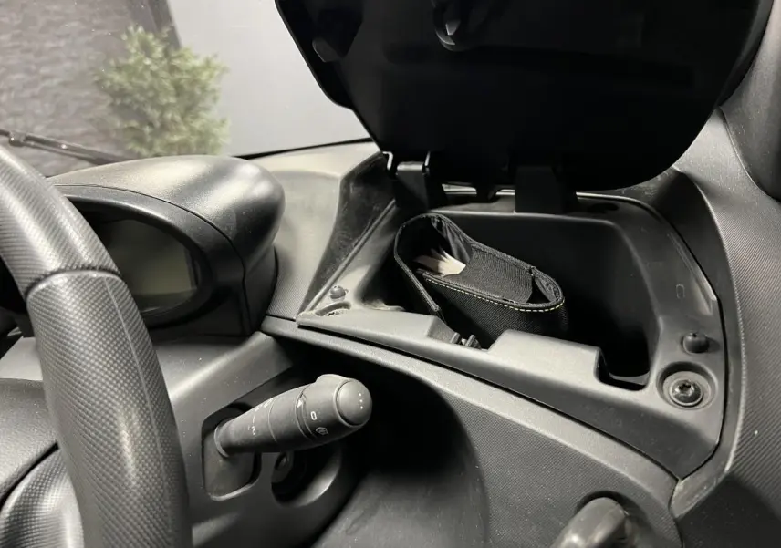 Intérieur Renault Twizy Intens 2019, vue rapprochée du tableau de bord avec boîte à gants ouverte et volant noir texturé.