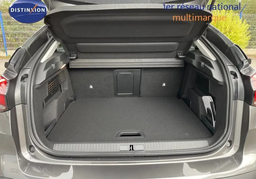 Coffre ouvert vu de l'arrière d'une Citroën C4 2024 gris platinium métal, montrant un espace de chargement spacieux et propre.