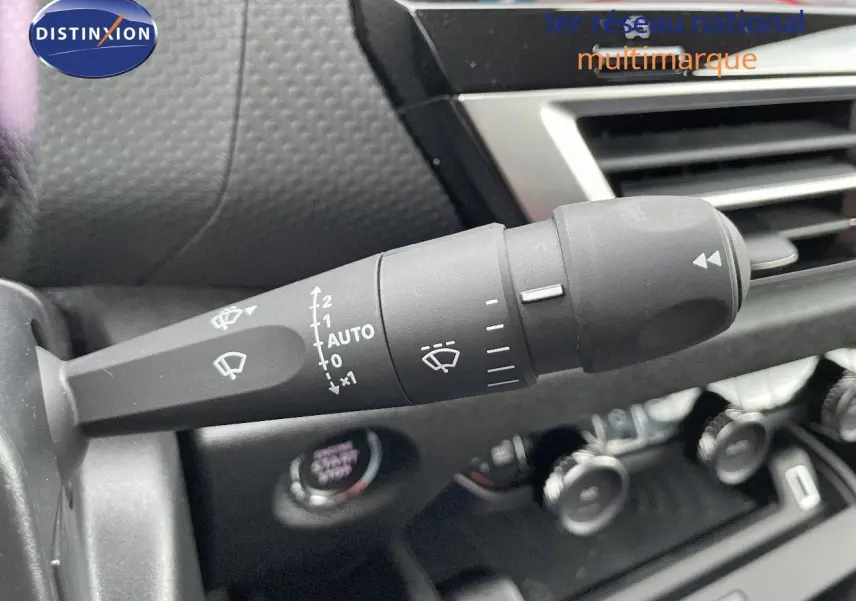 Gros plan sur la commande d’essuie-glace à gauche du tableau de bord d’une Citroën C4 gris platinium 2024.