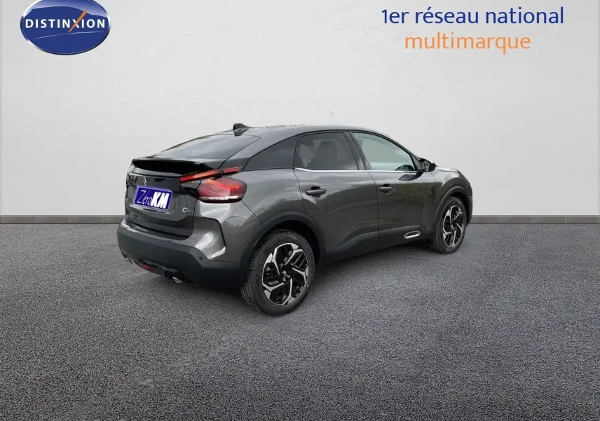 Vue 3/4 arrière droite d'une Citroën C4 2024 gris platinium métal avec jantes bi-ton et feux LED distinctifs.