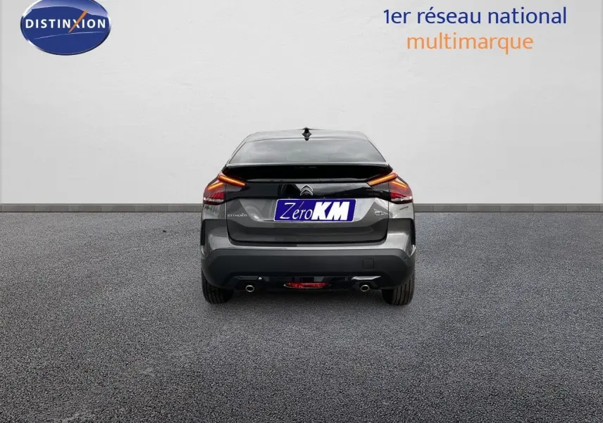 Vue arrière d'une Citroën C4 gris platinium métal 2024 avec feux LED et double sortie d'échappement visible.