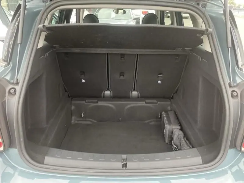 Coffre ouvert vu de l'arrière d'une MINI Countryman Cooper 136 gris 2021, intérieur spacieux et bien agencé.