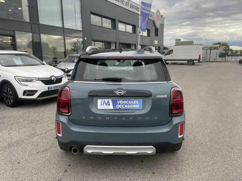 Vue arrière d'une MINI Countryman Cooper 136 gris 2021 avec logo et plaque d'occasion sur parking extérieur.