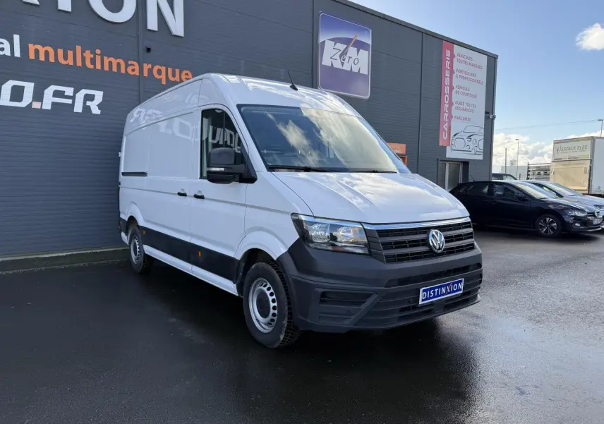 Volkswagen Crafter fourgon blanc vu en 3/4 avant droit, avec pare-chocs noir et porte coulissante à droite visible.