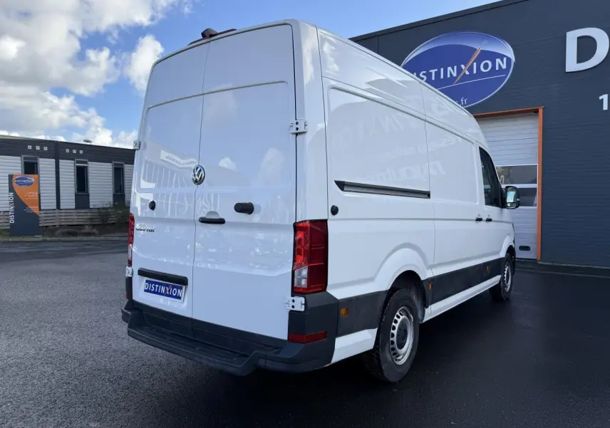 Volkswagen Crafter fourgon blanc vu en 3/4 arrière droit, toit haut H3, porte coulissante droite visible.