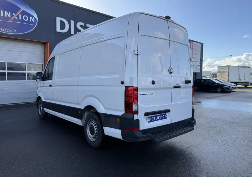 Vue 3/4 arrière droite d'un Volkswagen Crafter blanc, fourgon utilitaire avec toit haut et porte coulissante à droite.