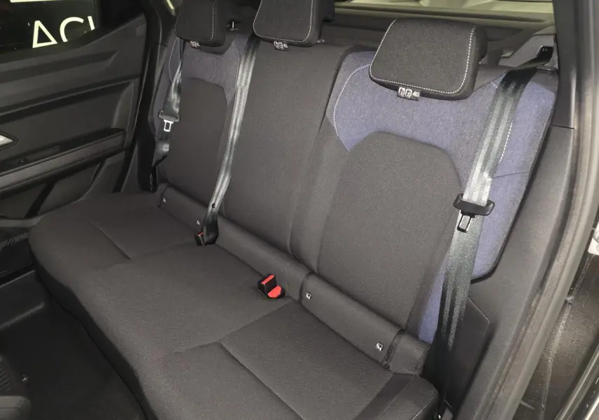 Vue latérale de la banquette arrière noire et denim bleu du Dacia Duster 1.6 Hybrid 2025 avec ceintures trois points.