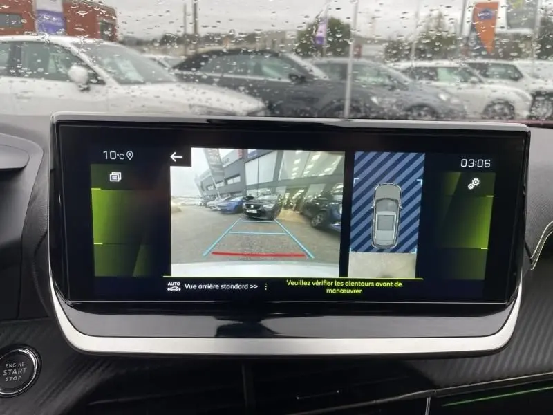 Écran de tableau de bord montrant la caméra de recul et l'affichage 360° du Peugeot 2008 rouge métal, vue intérieure avant.